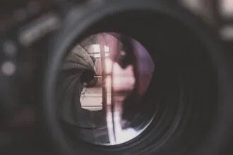 a close up of a camera lens with a person's reflection in it